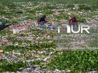 Residents on boats are collecting recyclable plastics from the heavily polluted Citarum River in Batujajar, Bandung, West Java, Indonesia, o...