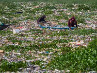 Residents on boats are collecting recyclable plastics from the heavily polluted Citarum River in Batujajar, Bandung, West Java, Indonesia, o...