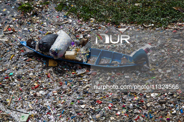 Residents on boats are collecting recyclable plastics from the heavily polluted Citarum River in Batujajar, Bandung, West Java, Indonesia, o...