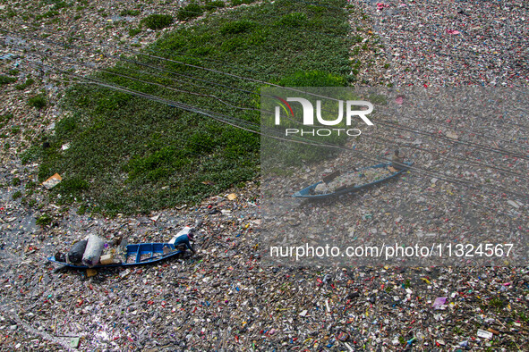 Residents on boats are collecting recyclable plastics from the heavily polluted Citarum River in Batujajar, Bandung, West Java, Indonesia, o...