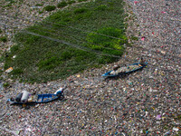 Residents on boats are collecting recyclable plastics from the heavily polluted Citarum River in Batujajar, Bandung, West Java, Indonesia, o...