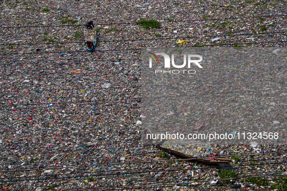 Residents on boats are collecting recyclable plastics from the heavily polluted Citarum River in Batujajar, Bandung, West Java, Indonesia, o...