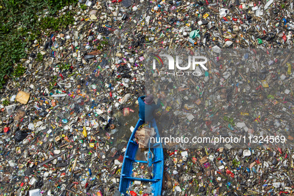 Residents on boats are collecting recyclable plastics from the heavily polluted Citarum River in Batujajar, Bandung, West Java, Indonesia, o...