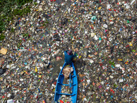 Residents on boats are collecting recyclable plastics from the heavily polluted Citarum River in Batujajar, Bandung, West Java, Indonesia, o...