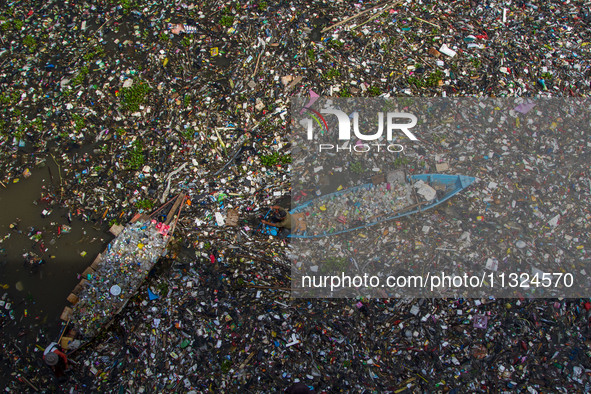 Residents on boats are collecting recyclable plastics from the heavily polluted Citarum River in Batujajar, Bandung, West Java, Indonesia, o...