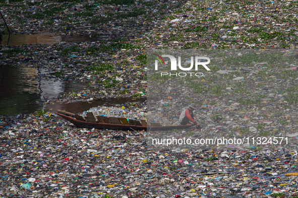 Residents on boats are collecting recyclable plastics from the heavily polluted Citarum River in Batujajar, Bandung, West Java, Indonesia, o...