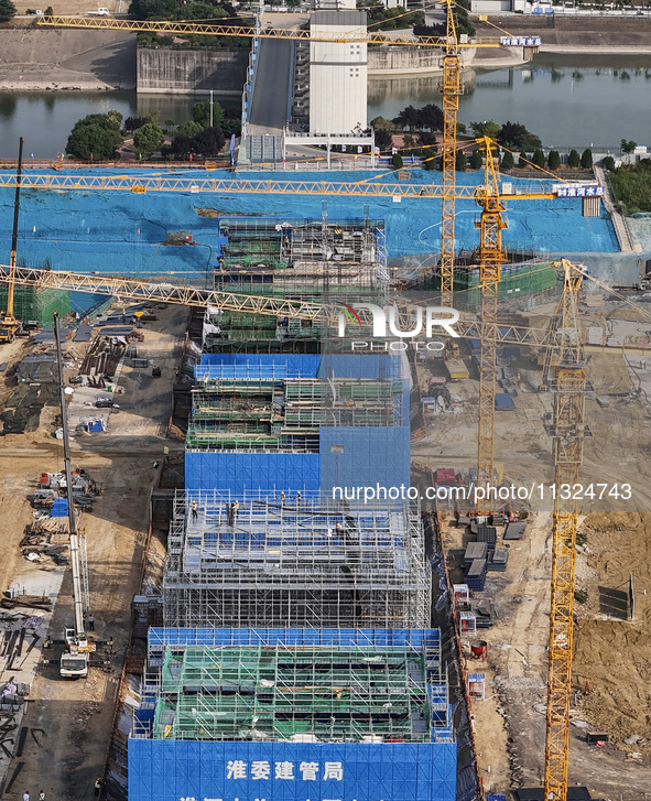 Workers are working on the construction of the second phase of the Huaihe River estuary waterway project in the second river hub section in...