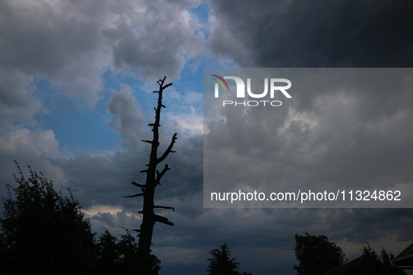 Dark clouds are hovering above residential houses during a windy and rainy day in Srinagar, India, on June 12, 2024. 