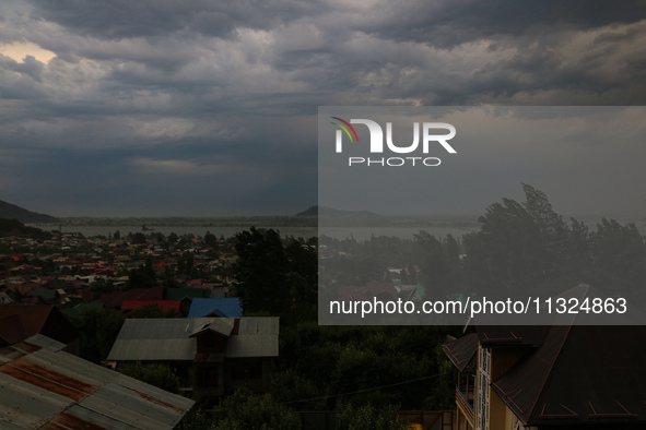 Dark clouds are hovering above residential houses during a windy and rainy day in Srinagar, India, on June 12, 2024. 