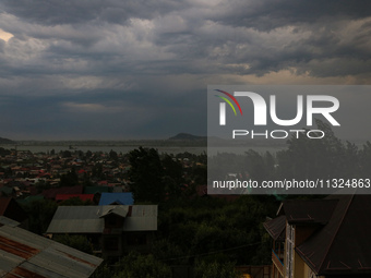 Dark clouds are hovering above residential houses during a windy and rainy day in Srinagar, India, on June 12, 2024. (