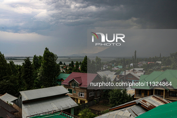 Dark clouds are hovering above residential houses during a windy and rainy day in Srinagar, India, on June 12, 2024. 