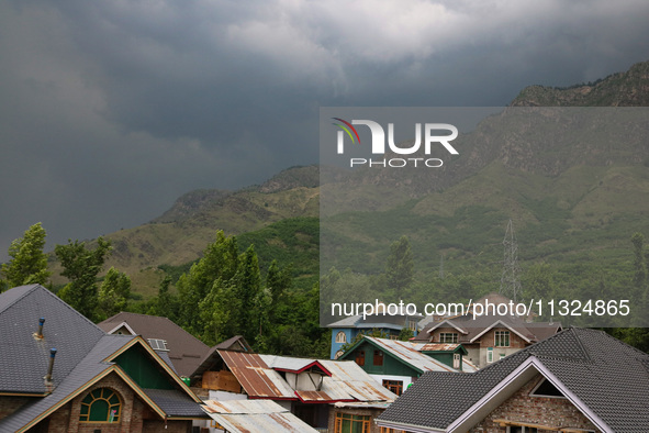 Dark clouds are hovering above residential houses during a windy and rainy day in Srinagar, India, on June 12, 2024. 