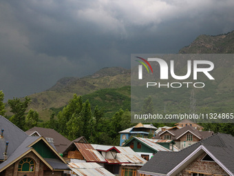 Dark clouds are hovering above residential houses during a windy and rainy day in Srinagar, India, on June 12, 2024. (