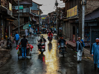 Commuters are walking after light rainfall in Sopore, Jammu and Kashmir, India, on June 12, 2024 (