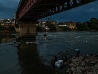 A young man is catching fish on the banks of River Jhelum after light rainfall in Sopore, Jammu and Kashmir, India, on June 12, 2024 (