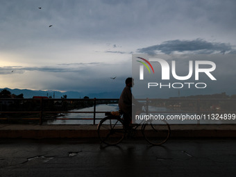 A man is riding his bicycle after light rainfall in Sopore, Jammu and Kashmir, India, on June 12, 2024 (