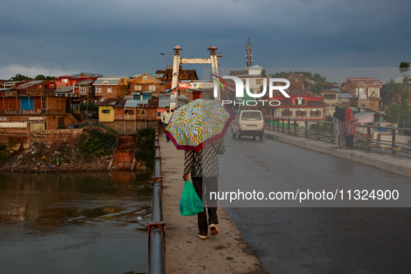 A man is walking as he is holding an umbrella after light rainfall in Sopore, Jammu and Kashmir, India, on June 12, 2024 