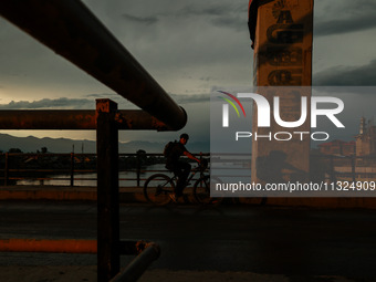 A boy is riding a bicycle during sunset after rainfall in Sopore, Jammu and Kashmir, India, on June 12, 2024 (