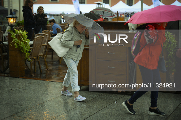 People are seen sheltering from a sudden downpour in Warsaw, Poland on 02 June, 2024. 