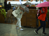 People are seen sheltering from a sudden downpour in Warsaw, Poland on 02 June, 2024. (