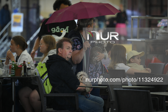 People are seen sheltering from a sudden downpour in Warsaw, Poland on 02 June, 2024. 