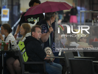 People are seen sheltering from a sudden downpour in Warsaw, Poland on 02 June, 2024. (