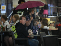 People are seen sheltering from a sudden downpour in Warsaw, Poland on 02 June, 2024. (