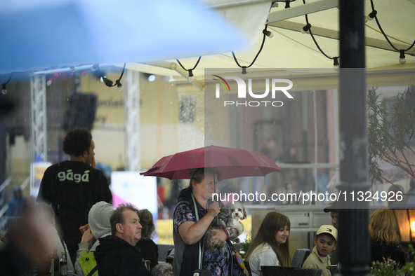 People shelter at a restaurant from a sudden downpour in Warsaw, Poland on 02 June, 2024. 