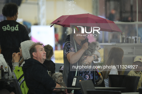 People shelter at a restaurant from a sudden downpour in Warsaw, Poland on 02 June, 2024. 