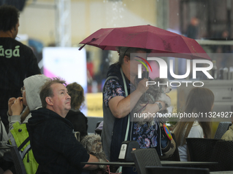 People shelter at a restaurant from a sudden downpour in Warsaw, Poland on 02 June, 2024. (