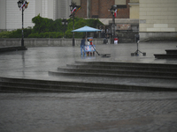 A worker shelters from the rain in Warsaw, Poland on 02 June, 2024. (