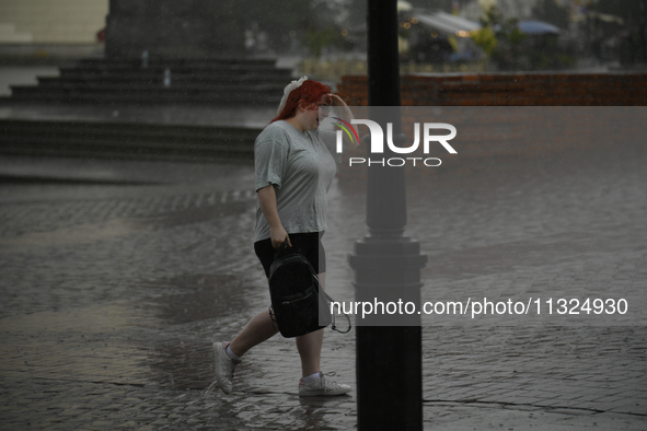 People are seen sheltering from a sudden downpour in Warsaw, Poland on 02 June, 2024. 