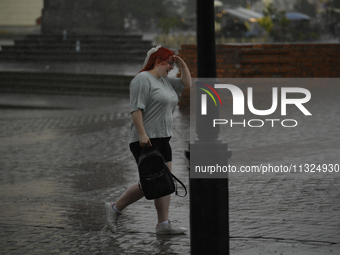 People are seen sheltering from a sudden downpour in Warsaw, Poland on 02 June, 2024. (