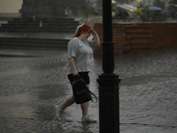 People are seen sheltering from a sudden downpour in Warsaw, Poland on 02 June, 2024. (