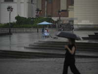 People are seen sheltering from a sudden downpour in Warsaw, Poland on 02 June, 2024. (