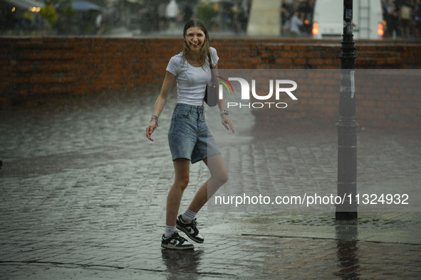 People are seen sheltering from a sudden downpour in Warsaw, Poland on 02 June, 2024. 