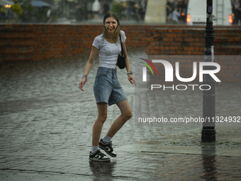 People are seen sheltering from a sudden downpour in Warsaw, Poland on 02 June, 2024. (