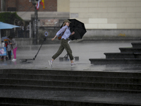 People are seen sheltering from a sudden downpour in Warsaw, Poland on 02 June, 2024. (