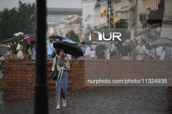 People are seen sheltering from a sudden downpour in Warsaw, Poland on 02 June, 2024. 