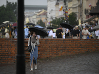 People are seen sheltering from a sudden downpour in Warsaw, Poland on 02 June, 2024. (