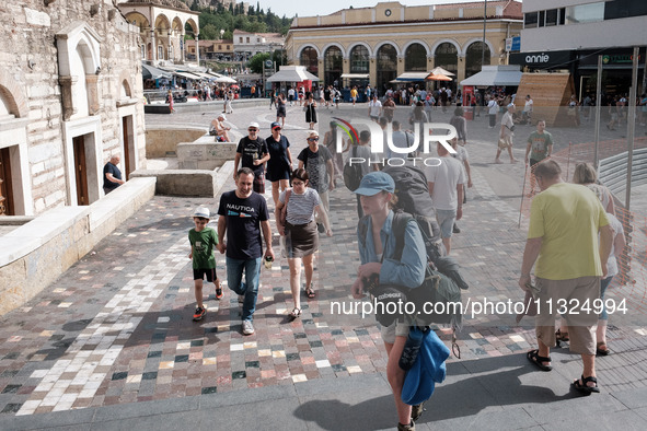 Tourists are walking at Monastiraki Square during a heatwave in Athens, Greece, on June 12, 2024. Many of the country's schools are remainin...