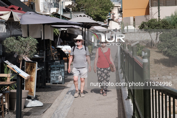 Tourists are wearing hats near Monastiraki Square during a heatwave in Athens, Greece, on June 12, 2024. Many of the country's schools are r...