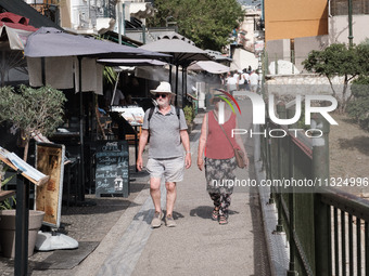 Tourists are wearing hats near Monastiraki Square during a heatwave in Athens, Greece, on June 12, 2024. Many of the country's schools are r...