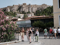 Tourists are walking in front of Acropolis Hill near Monastiraki Square during a heatwave in Athens, Greece, on June 12, 2024. Many of the c...