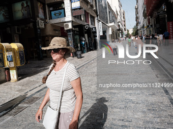 A woman is wearing a hat to protect from the sun near Monastiraki Square during a heatwave in Athens, Greece, on June 12, 2024. Many of the...