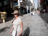 A woman is wearing a hat to protect from the sun near Monastiraki Square during a heatwave in Athens, Greece, on June 12, 2024. Many of the...