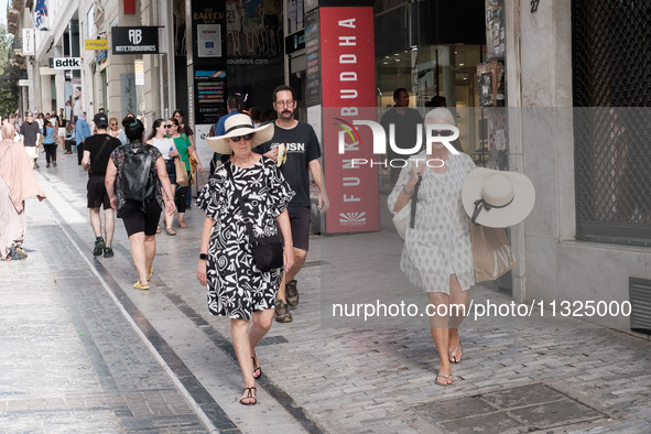 A woman is wearing a hat to protect from the sun near Monastiraki Square during a heatwave in Athens, Greece, on June 12, 2024. Many of the...