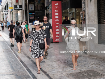 A woman is wearing a hat to protect from the sun near Monastiraki Square during a heatwave in Athens, Greece, on June 12, 2024. Many of the...