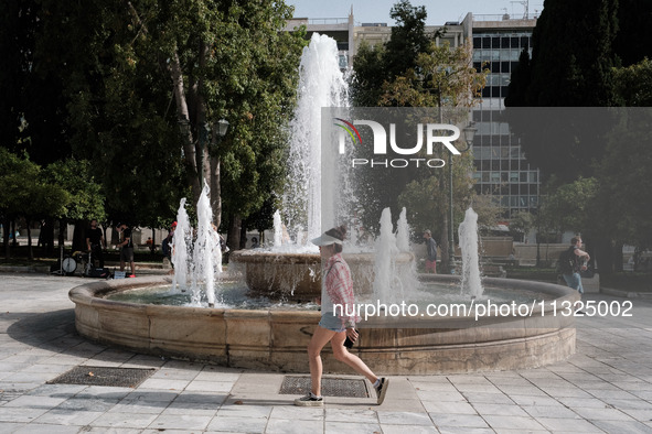 A woman is wearing a hat to protect from the sun at Syntagma Square during a heatwave in Athens, Greece, on June 12, 2024. Many of the count...