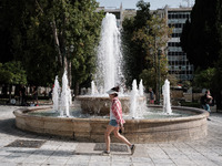 A woman is wearing a hat to protect from the sun at Syntagma Square during a heatwave in Athens, Greece, on June 12, 2024. Many of the count...